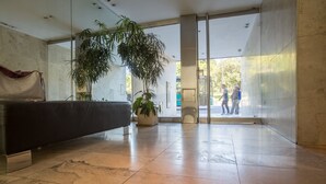 A spacious lobby with a marble floor, a reception desk, and large windows allowing natural light. - Las Heras by Be Local Argentina (Buenos Aires)