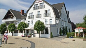 A white building with a sign reading "HOTEL Vier Linden Restaurant." - Hotel Vier Linden (Kellenhusen)