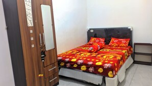 Une chambre à coucher avec un lit, une armoire et une table de chevet.