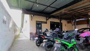 Un espace de stationnement couvert où des motos sont garées sous un toit métallique.