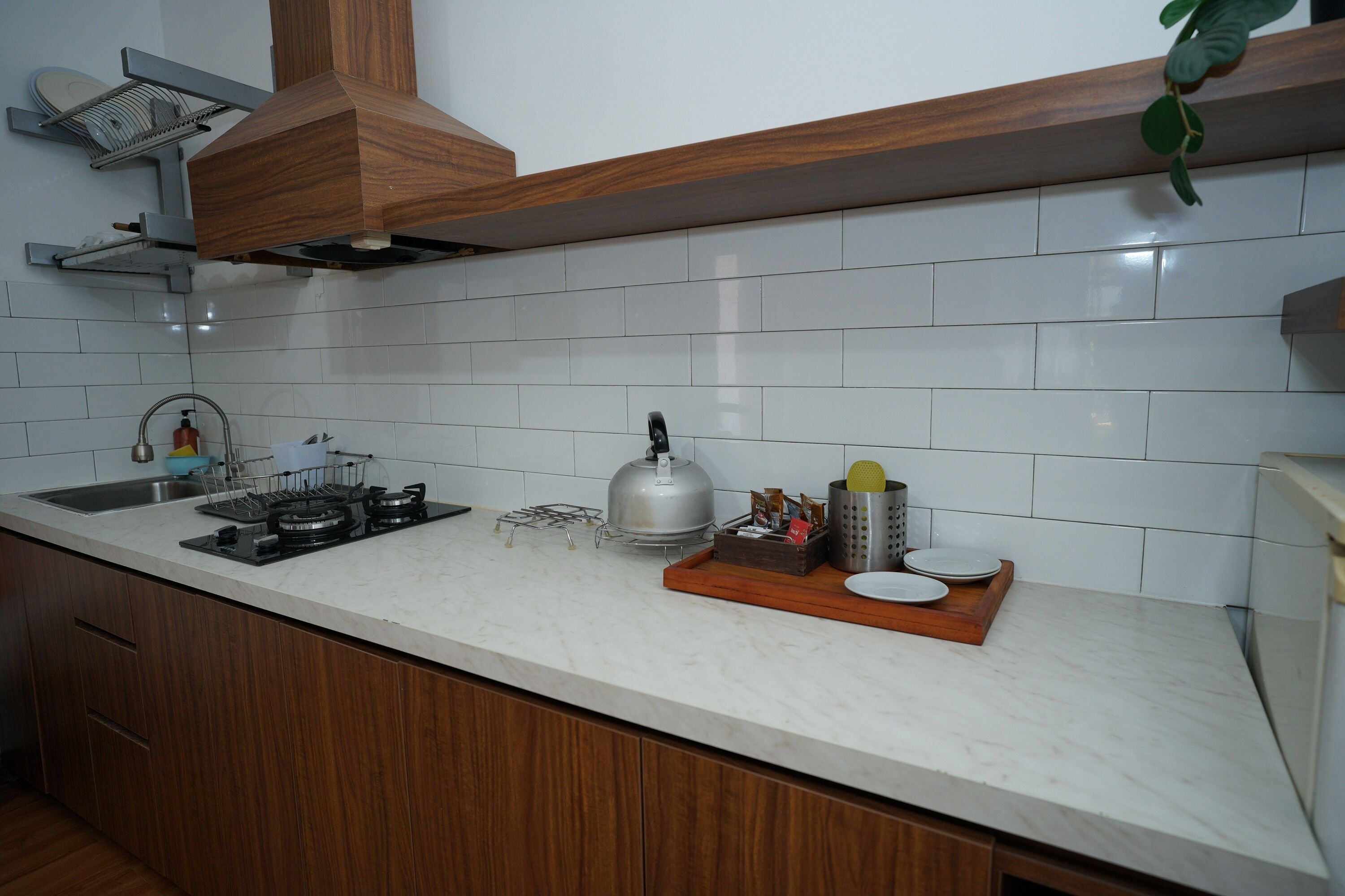 A modern kitchen with a gas stove, a kettle, and a coffee machine.