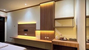 Habitación de hotel moderna con una pared decorativa de madera, un escritorio empotrado con lámpara y una cama.