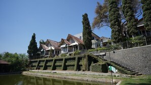 Una hilera de casas con un muro de piedra y un pequeño estanque al frente.