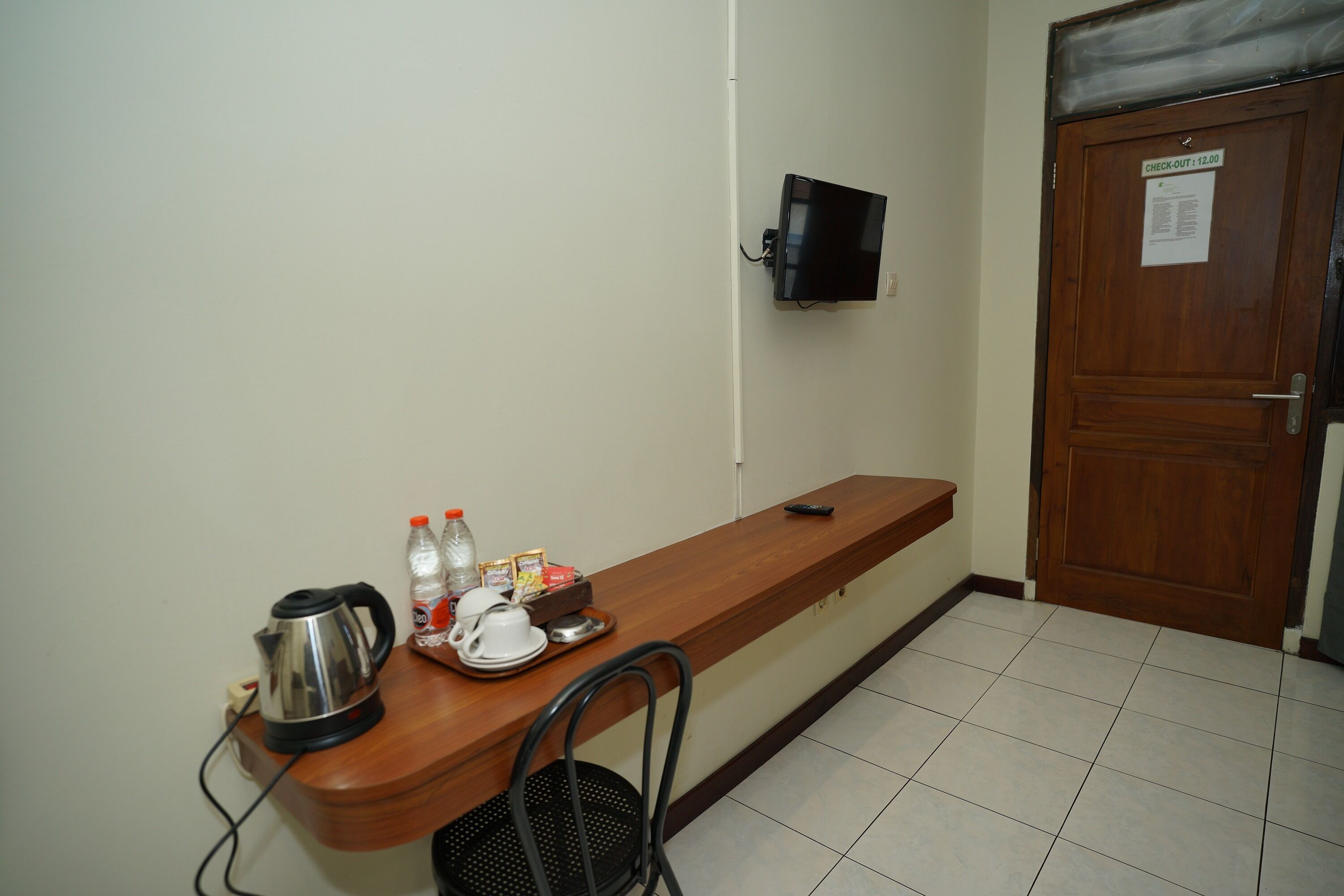 A small kitchenette with a coffee maker, kettle, and breakfast items on a wooden counter.
