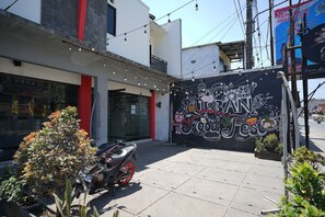 Vista de una calle con una motocicleta estacionada frente a un edificio con un mural que dice 'URBAN Food Fest'.