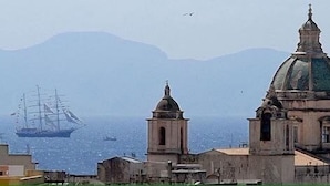 A coastal cityscape with a prominent church and a large ship in the background. - Dragonfly B&B (Trapani)