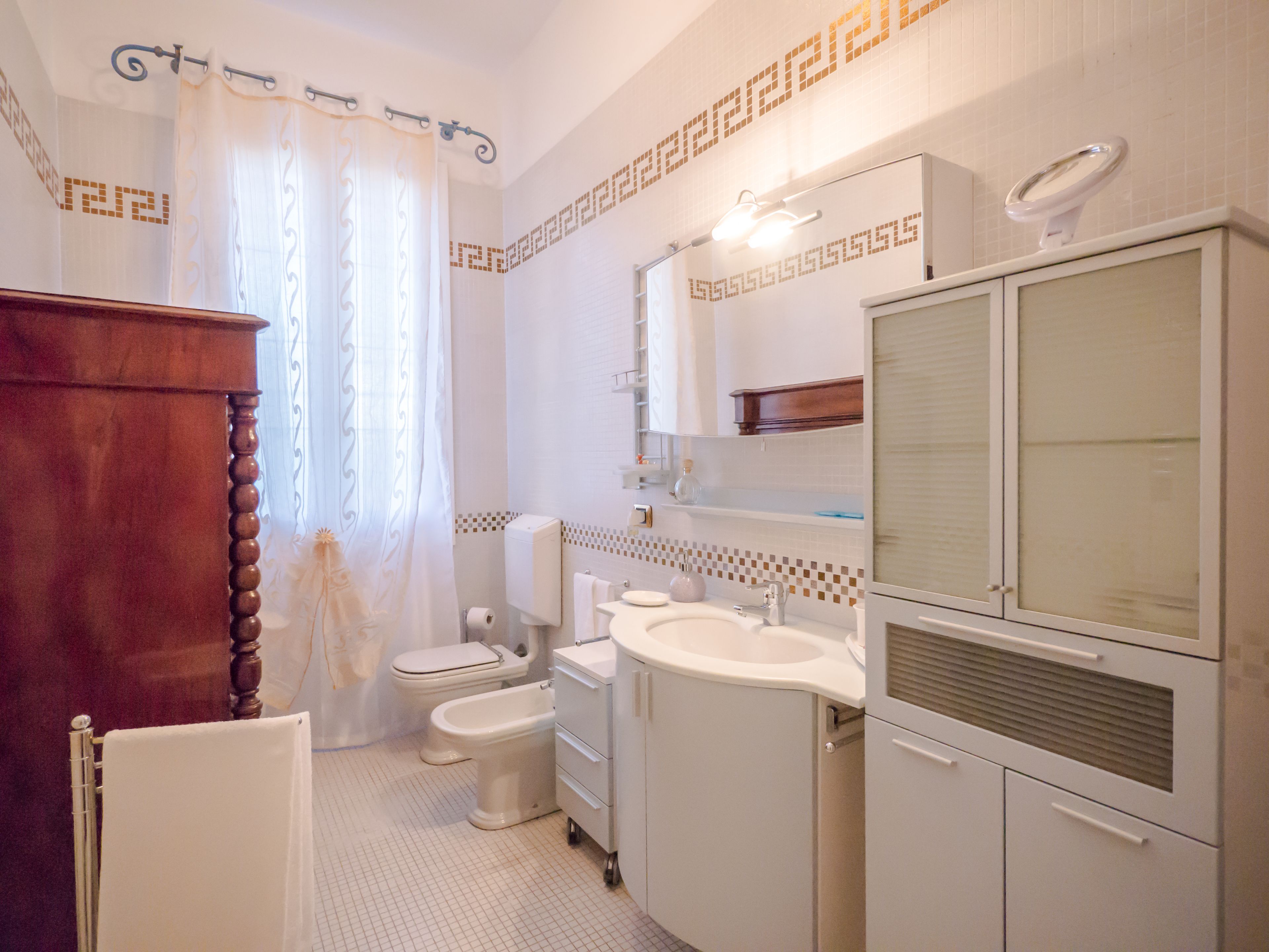 A bathroom with a toilet, sink, and vanity.