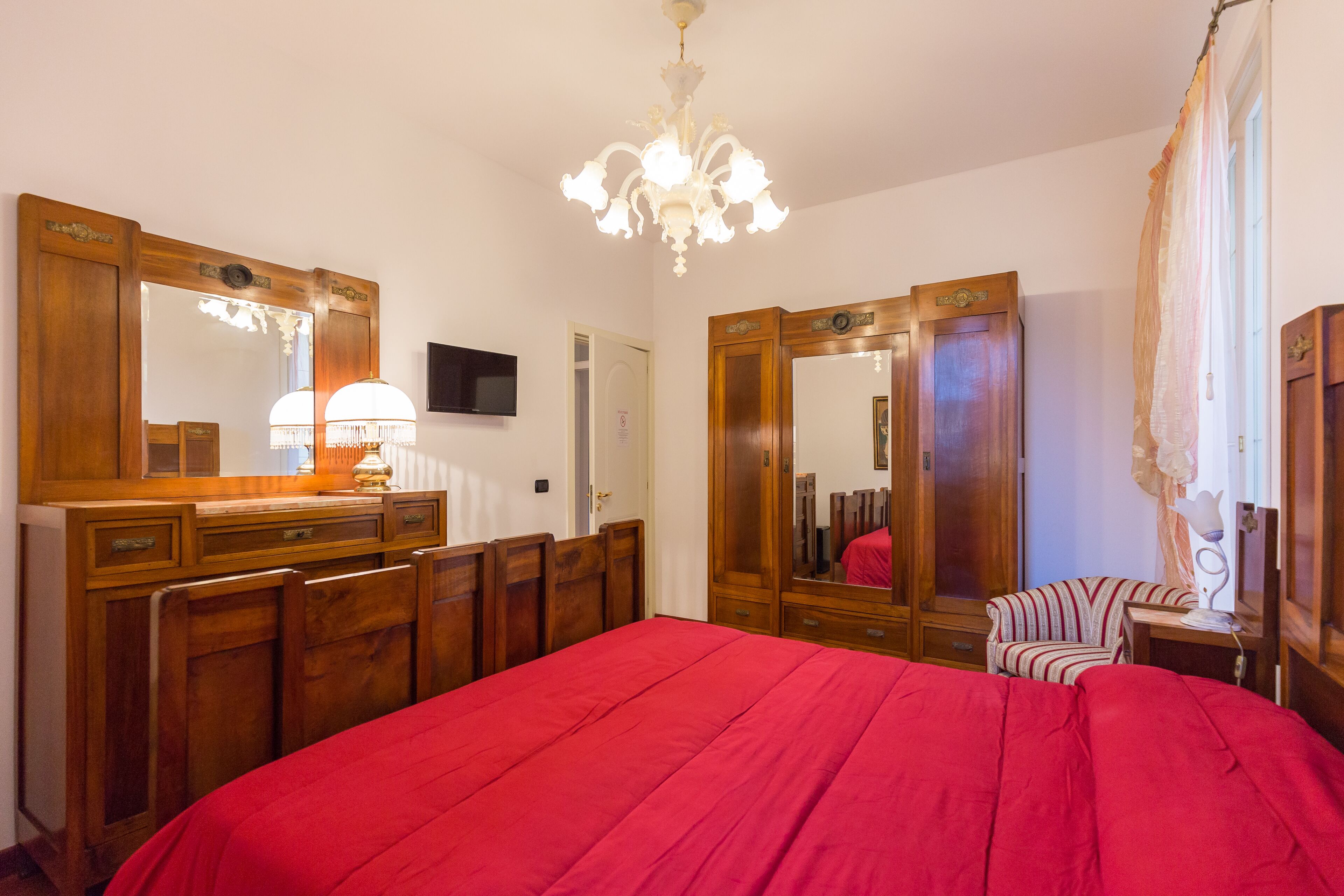 Una camera da letto con un letto grande, un armadio in legno e uno specchio.