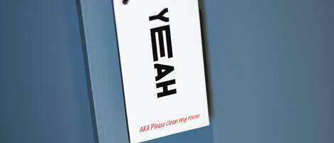 A white sign with black text on a blue wall.