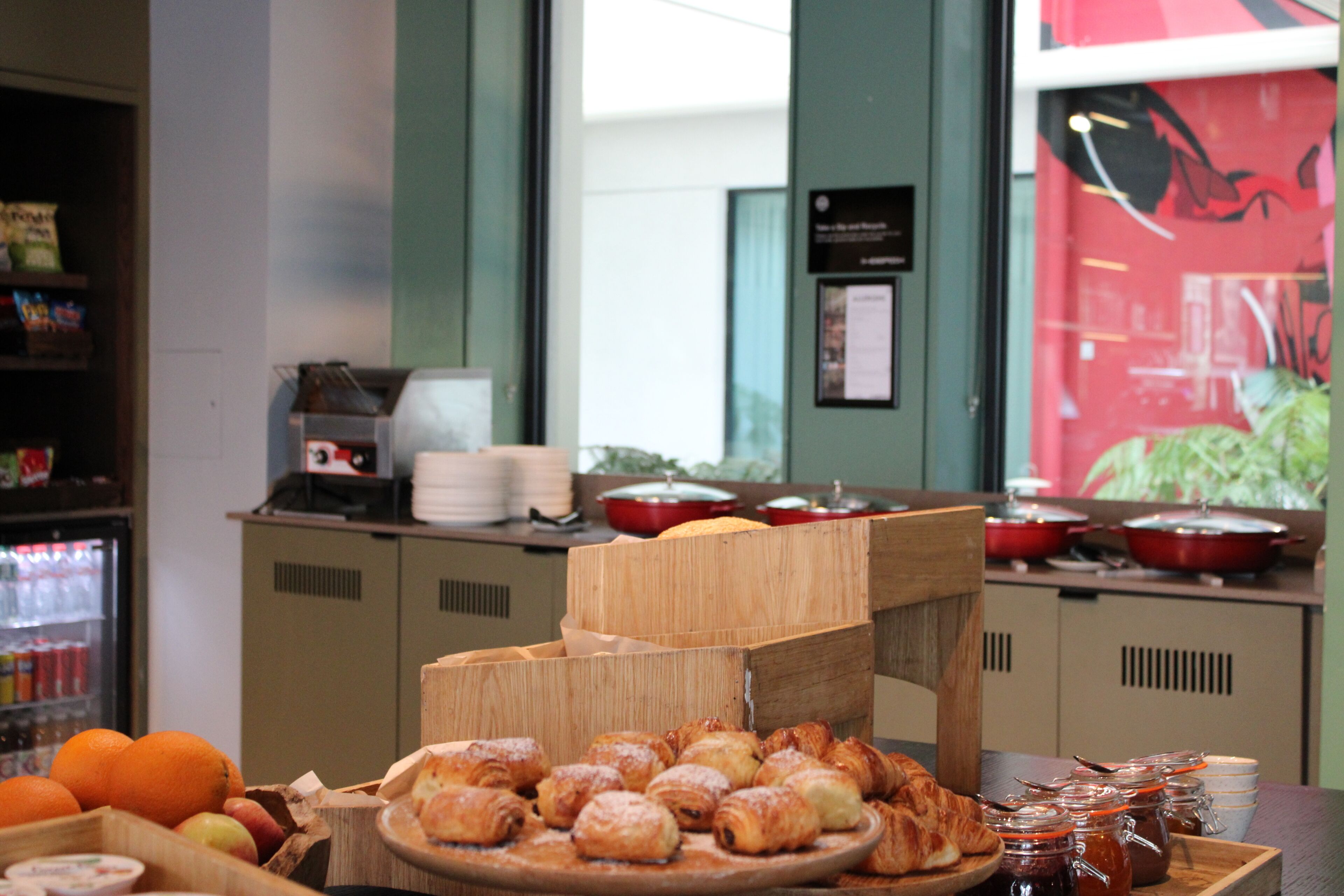 A buffet setup with pastries, fruits, and condiments.
