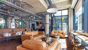 Un área de estar moderna con sofás de cuero, una mesa de centro y una zona de bar con taburetes.