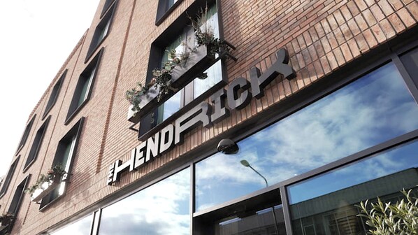 Un edificio con un letrero que dice 'HENDRICK'S' y fachada de ladrillo con varias ventanas.