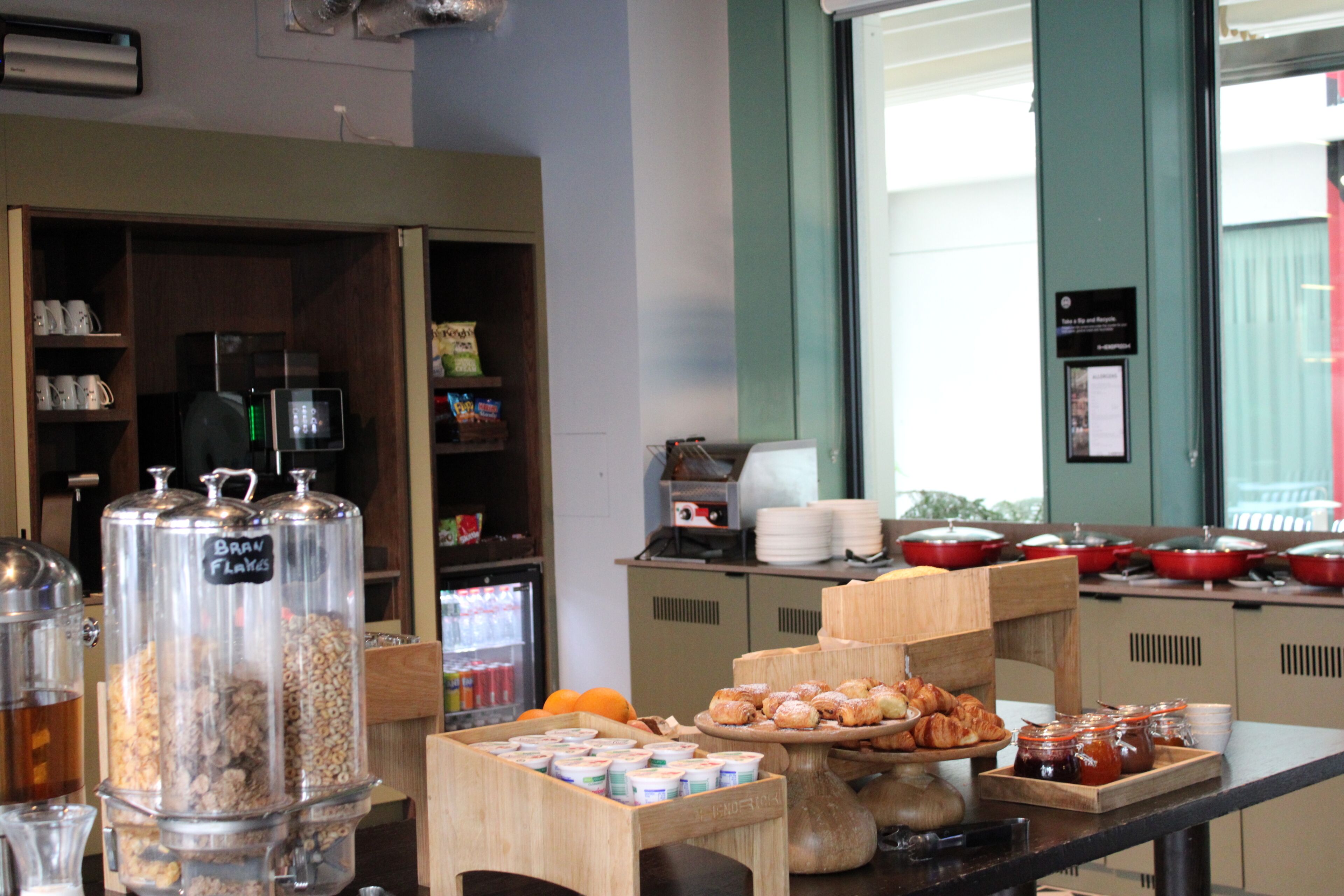 Un buffet per la colazione con diversi cibi e una macchina per il caffè.