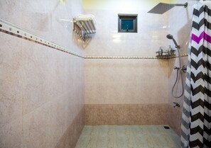 A bathroom with a shower, a towel rack, and a small window. - Paguro Villa (Ukulhas)