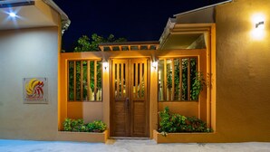 A building entrance with a wooden door, vertical windows, and a sign reading "PAGURO VILLA". - Paguro Villa (Ukulhas)