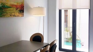 Ein Essbereich mit Tisch, Stühlen, einer Lampe und einem Bild an der Wand.