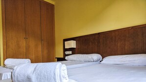 A hotel room with two beds, wooden wardrobe, and a nightstand. - Apartamentos Canillo Ribagrossa 3000 (Canillo)