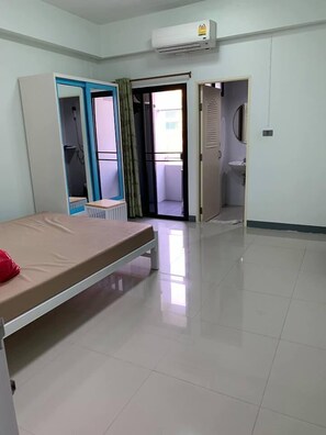 Een kamer met een bed, een kledingkast, een badkamer en een airconditioning.