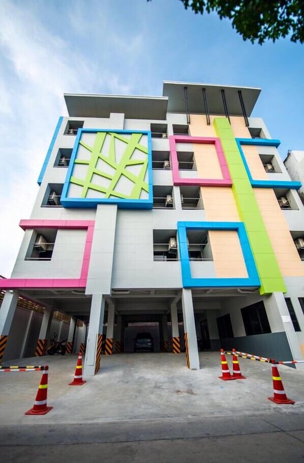 Een meerhoog gebouw met een modern ontwerp, met een geometrisch gevelfront met blauwe, roze en groene accenten.