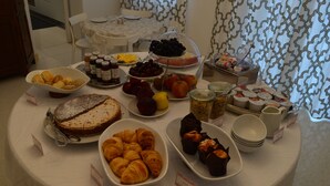 Una mesa de buffet con distintos alimentos, entre ellos pasteles, frutas y salsas.