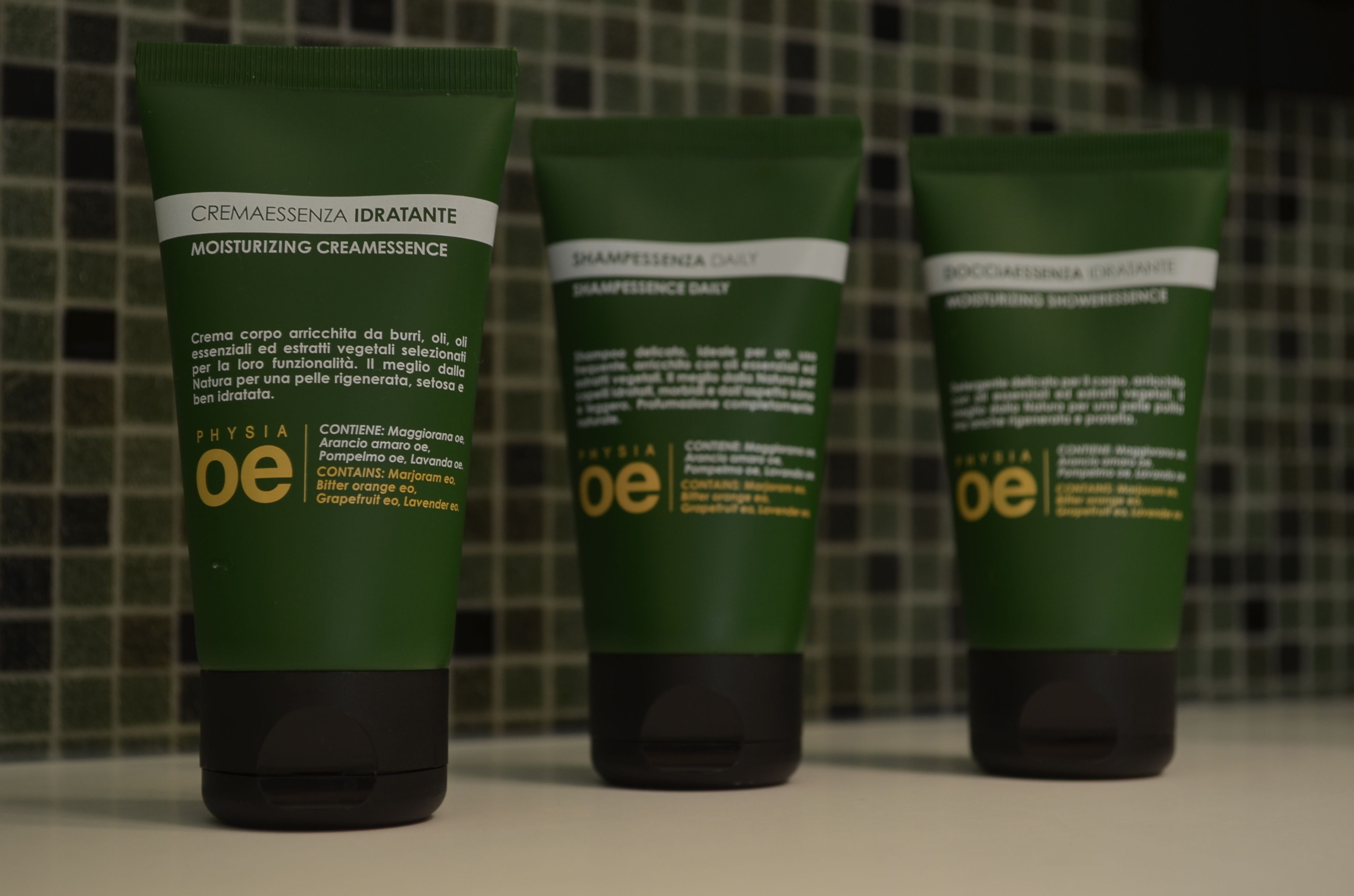 Three green tubes of skincare products with text in Italian.