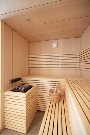 A wooden sauna with benches, a bench heater, and a bucket. - Antica Pusterla Relais De Charme (Vicenza)