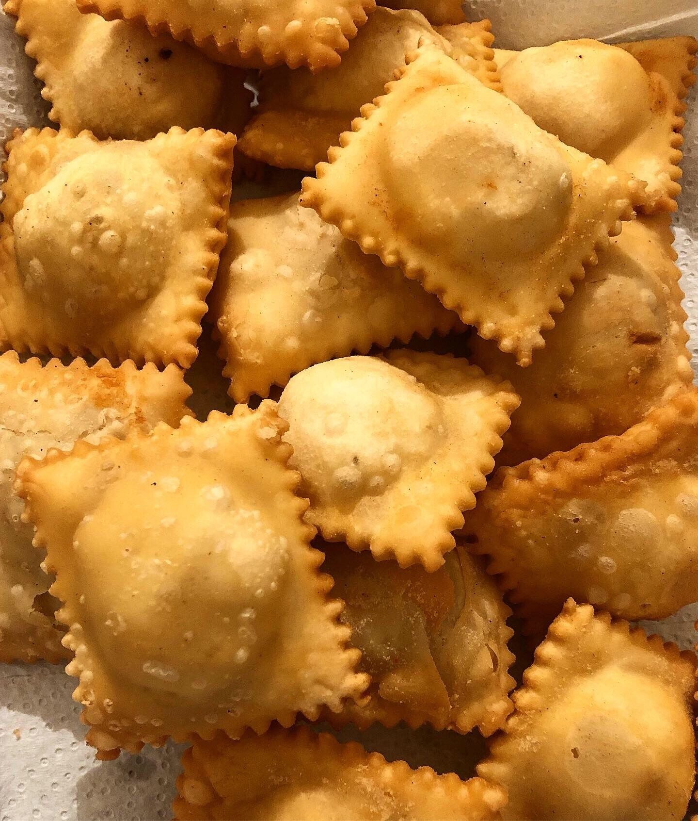 A tray of ravioli with a golden-brown crust.