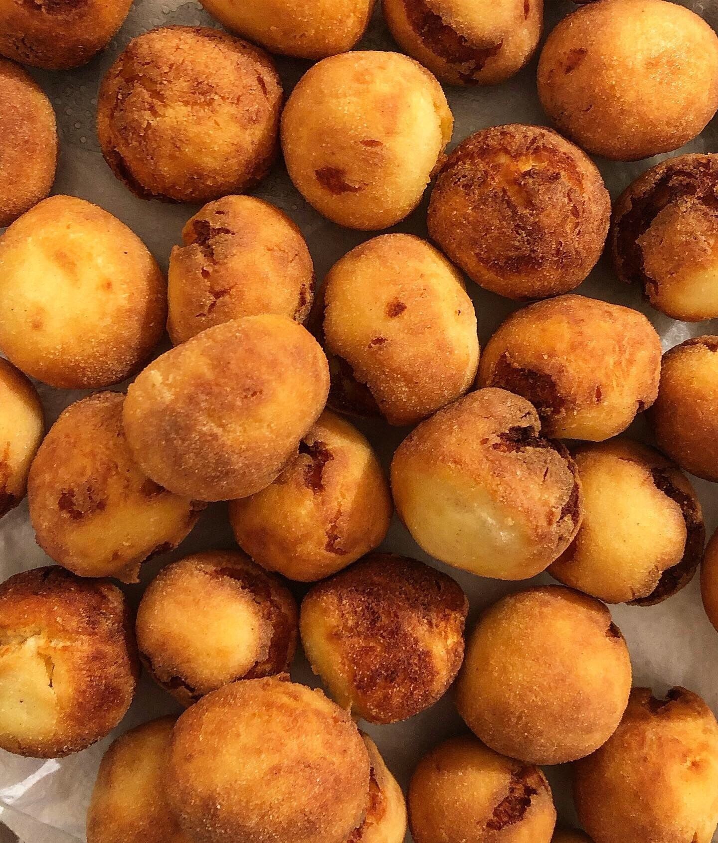 A tray of round, golden-brown fried food items, likely a type of fritter or snack.