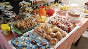 Ein reichhaltiges Buffet mit verschiedenen Speisen, darunter Gebäck, Sandwiches und Getränke.