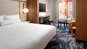A hotel room with a large bed, a desk with a chair, a television, and a window with curtains. - Fairfield Inn & Suites by Marriott Denver Tech Center North (Denver)