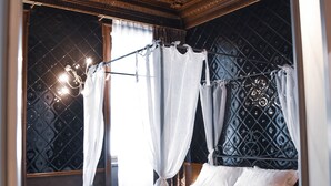 A luxurious bedroom with a canopy bed, a decorative ceiling, and a view of the night sky. - Ilsanleonardo - Suites (Bergamo)
