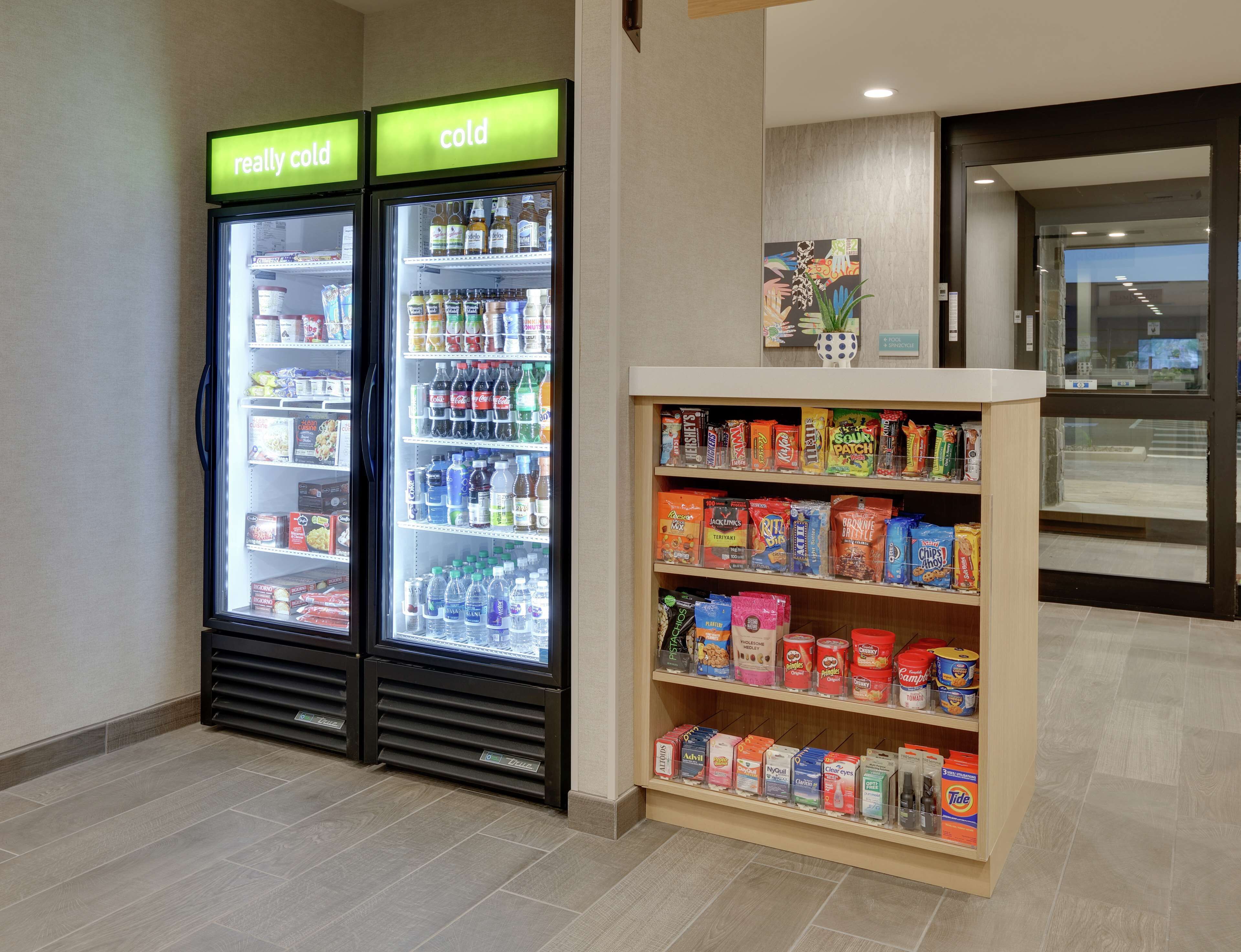 Dois dispensadores de bebidas refrigeradas, um com a etiqueta "bem gelado" e outro com a etiqueta "gelado", com diversas bebidas disponíveis.