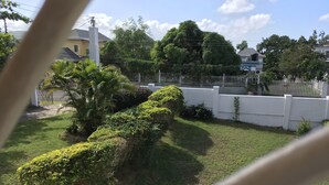 A well-maintained garden with neatly trimmed hedges, a white fence, and lush greenery. - Villa Edinburgh (Montego Bay)