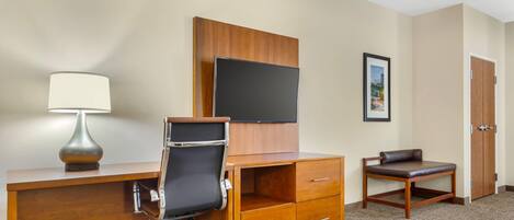 Une chambre d’hôtel équipée d’un bureau, d’une chaise, d’une télévision et d’un tableau encadré au mur.