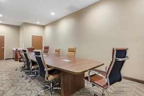 A conference room with a long table, multiple chairs, and a carpeted floor. - Comfort Suites Greensboro - High Point (Greensboro)
