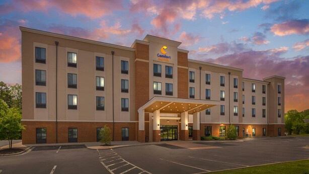 A hotel with a flat facade, multiple windows, and a covered entrance. - Comfort Suites Greensboro - High Point (Greensboro)
