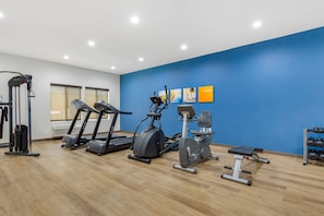 A gym with treadmills, an elliptical, a bench, and a rack of dumbbells. - Comfort Suites Greensboro - High Point (Greensboro)