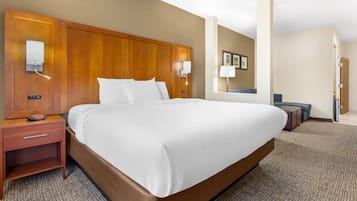 Ein Hotelzimmer mit einem großen Bett, Nachttischen, einem Schreibtisch und einem Sessel.