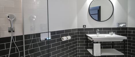 Un baño moderno con inodoro, lavamanos y ducha.