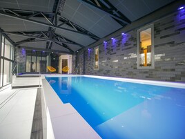 Una piscina techada, sillones reclinables de piscina