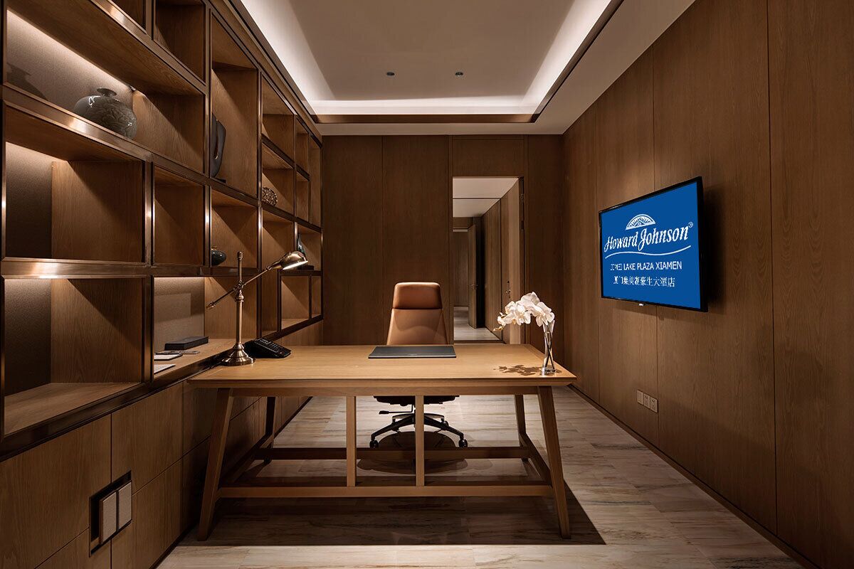 A modern office space with a desk, chair, and shelves.