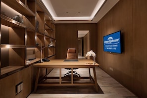 A modern office space with a desk, chair, and shelves.