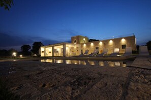A building with a pool, outdoor seating, and a stone facade. - Vita Dorata - Rural chic (Alberobello)
