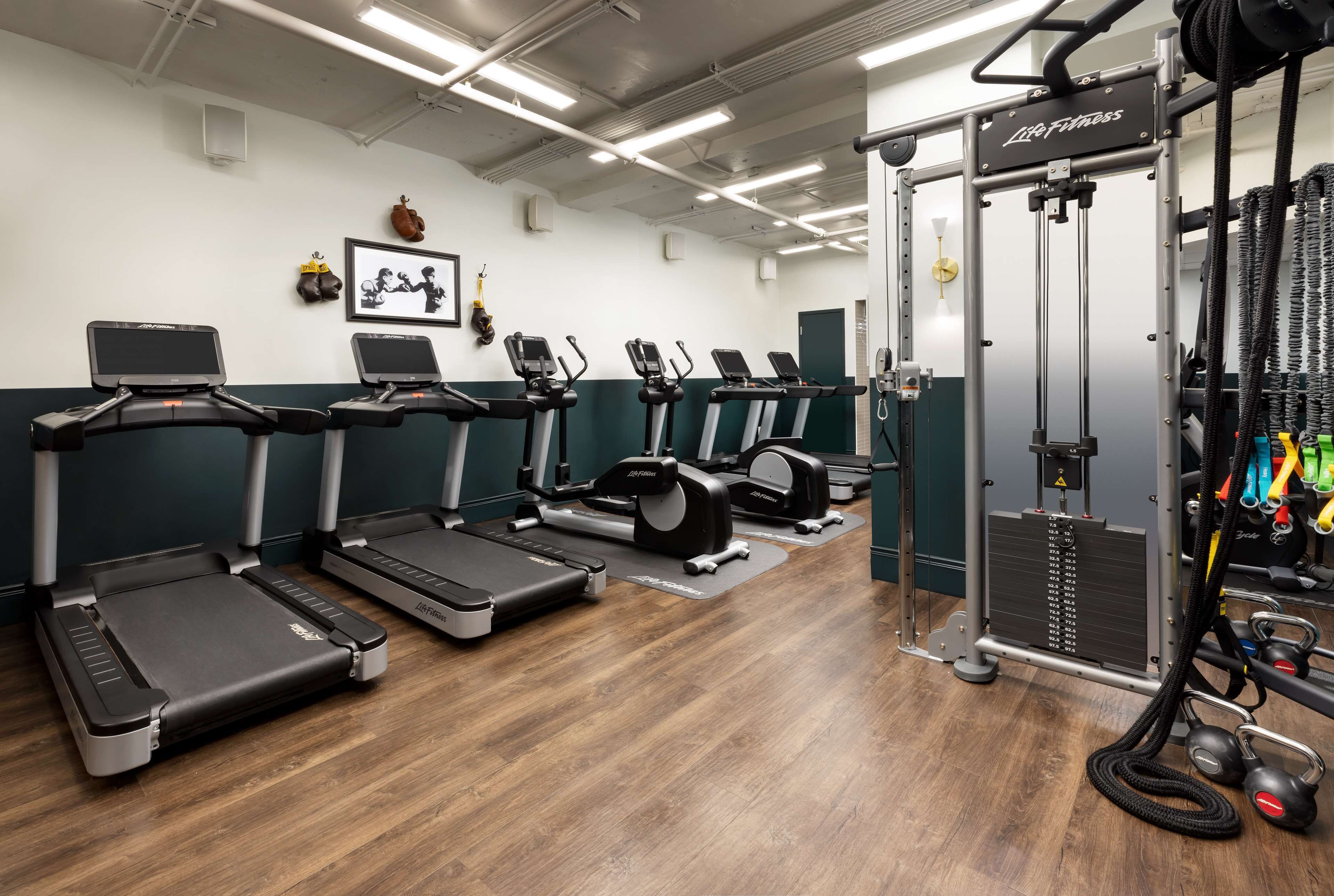A gym with treadmills, weight machines, and a cable machine.