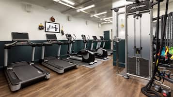 Ett gym med löpband, styrketräningsmaskiner och en kabelmaskin.