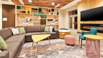 A modern living room with a sectional sofa, a coffee table, ottomans, and a fireplace.