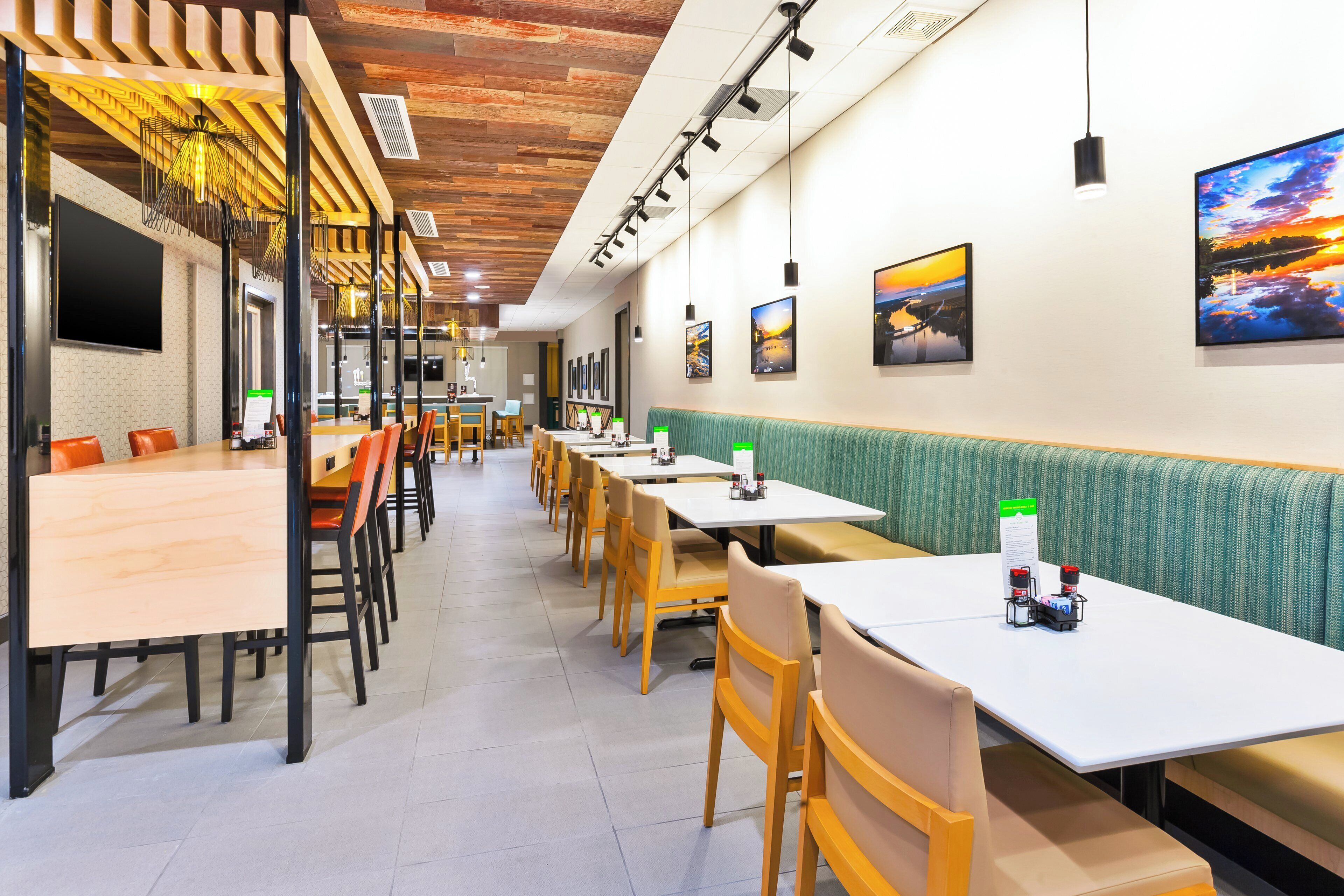 Un restaurante con mesas largas, cabinas y diversas opciones de asientos.