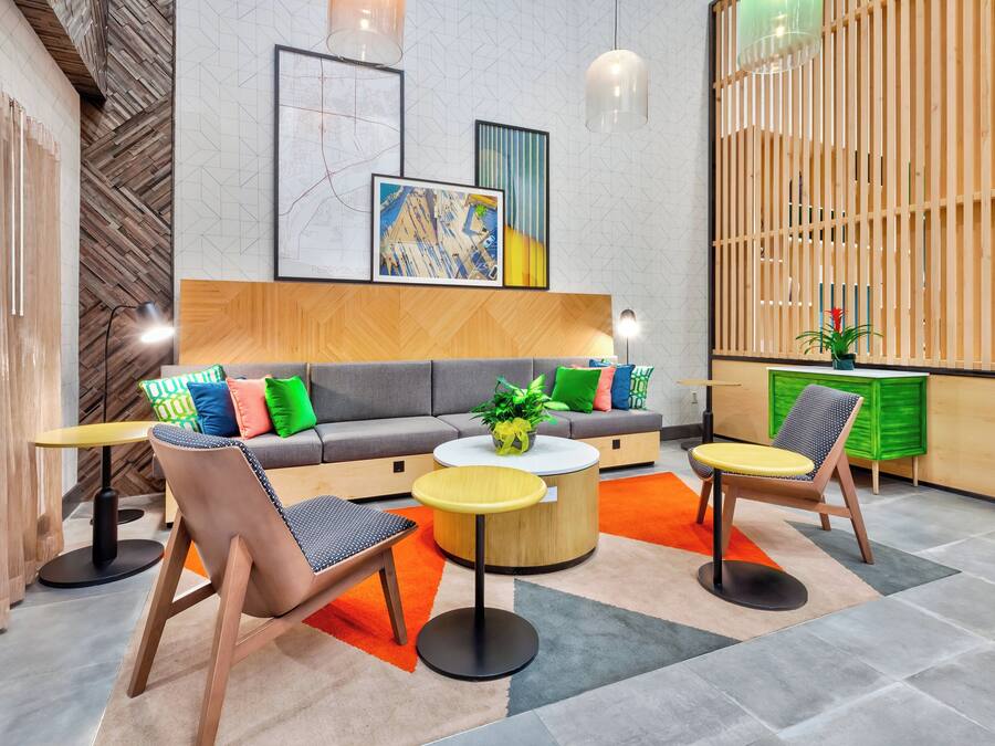 Un espace de détente moderne comprenant un canapé, des fauteuils, une table basse et une plante décorative.