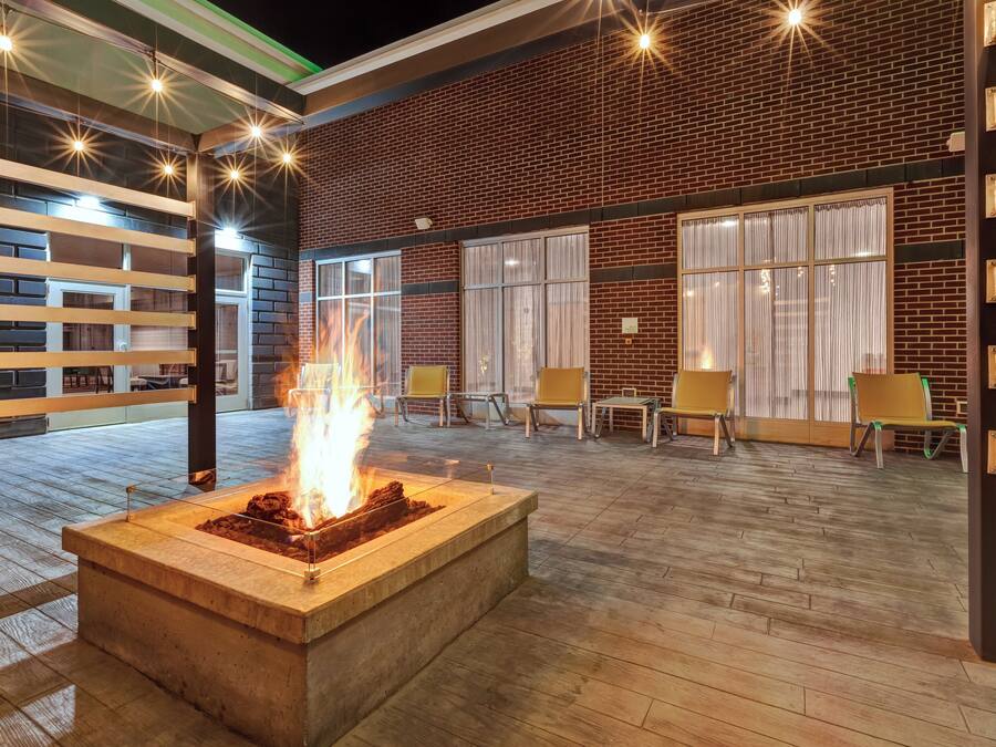 An outdoor seating area with a fire feature, brick walls, and modern furniture.