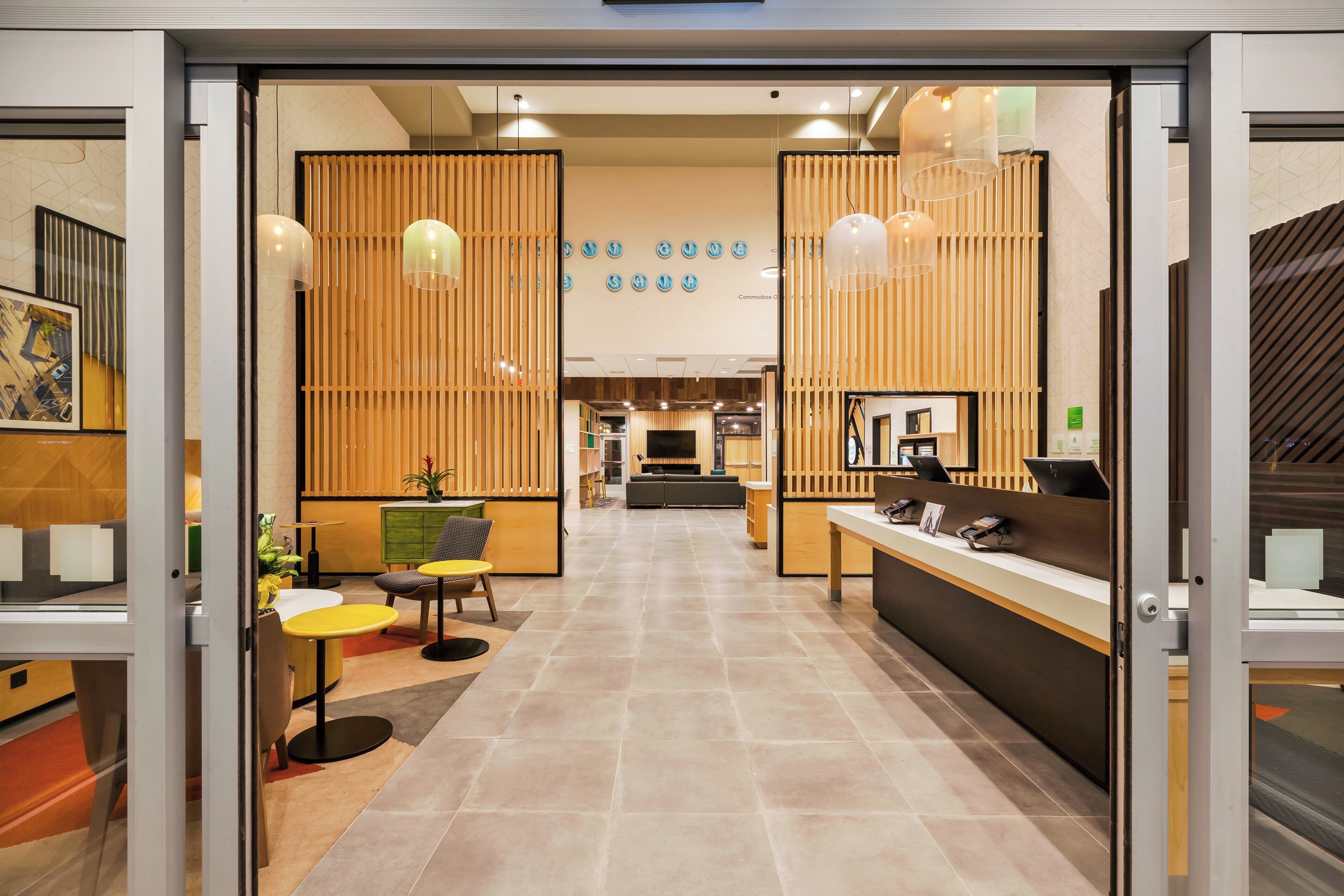 A hotel lobby with a reception desk, seating area, and a view of the interior.